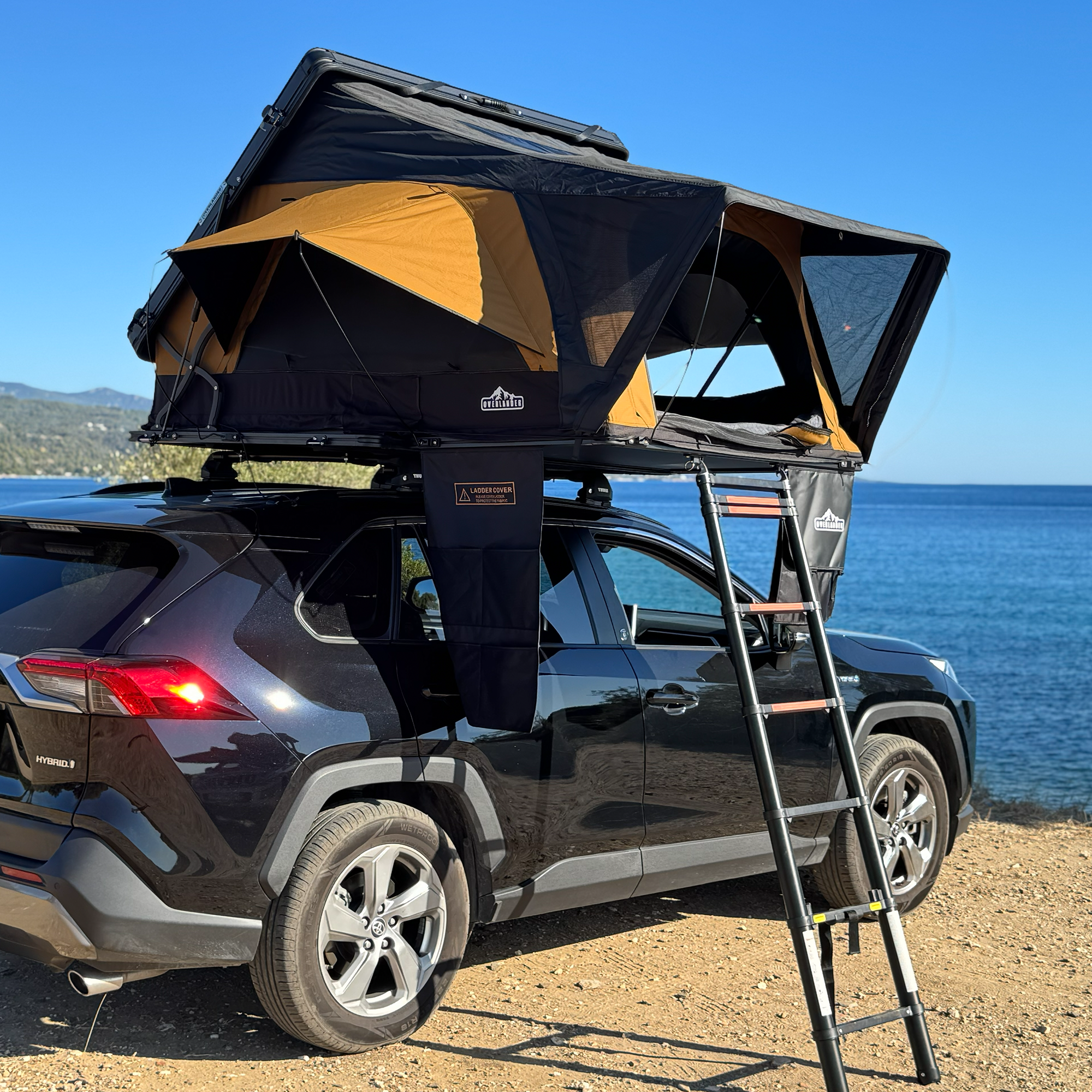 Overlander Nova Sahara rooftop tent open on an SUV beside the sea